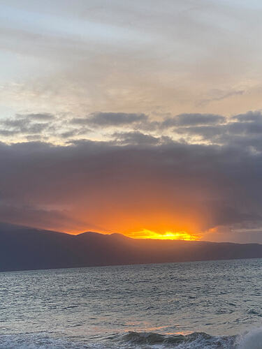 02-sunset-breaking-through-clouds-over-mountain-ridge